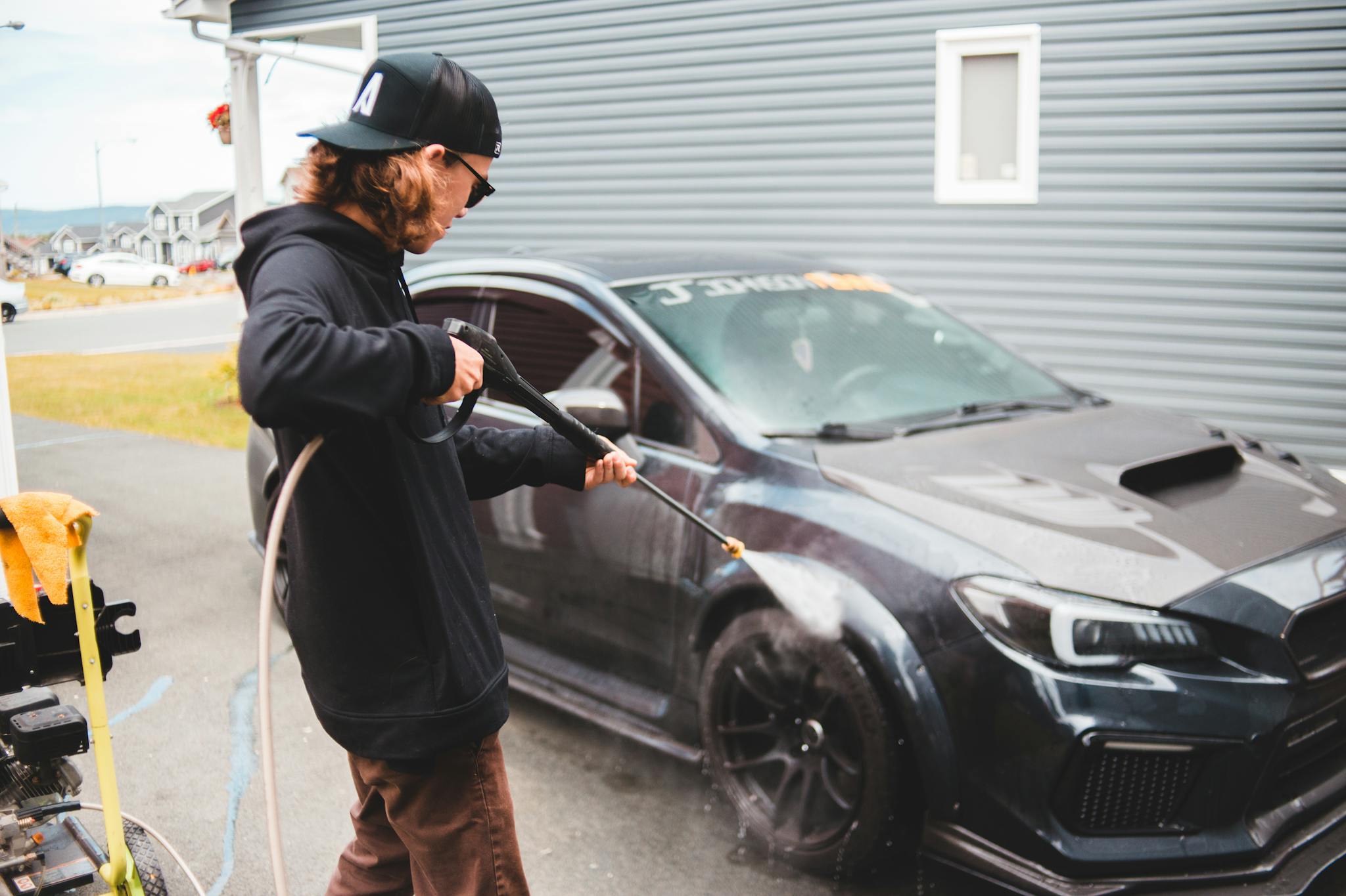 Concentrated man washing automobile at car wash